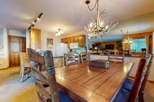 comedor y cocina con mesa de madera y sillas en Phoenix I, en Steamboat Springs