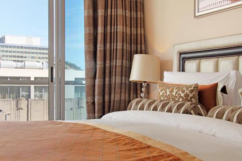 a bedroom with a bed and a large window at Taj Cape Town - private luxury 5 star suites - very spacious with kitchenette in Cape Town