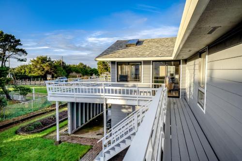 a home with a white deck with a view of the yard at The Chinook House in Depoe Bay