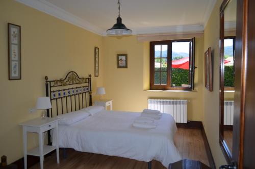 a bedroom with a white bed and a window at Apartamento Casona de la Viesca in Liendo