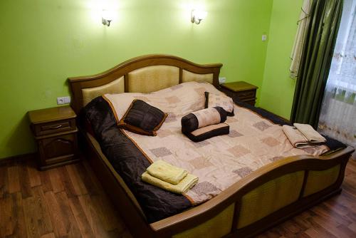 Cama en habitación verde con almohadas en У Стрия, en Skhidnytsya