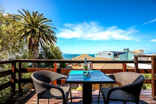 a table and chairs on a deck with a view of the ocean at Misty Waves Boutique Hotel in Hermanus