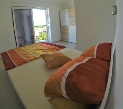 a bed with two pillows on it in a room at Apartmani Zaric in Malinska