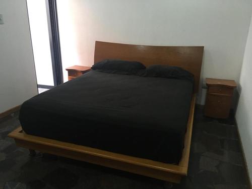 een bed in een kamer met 2 nachtkastjes en een bed sidx sidx sidx bij apartosuite plaza la boyera in Caracas