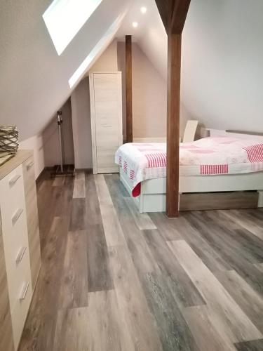 a attic bedroom with two beds and wooden floors at Haus Maisonette am Harz in Niedersachswerfen