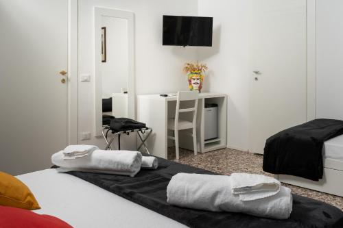 a bedroom with two beds and a desk with a chair at Regina Margherita - Bed and Breakfast & Rooftop Lounge Bar in Siracusa
