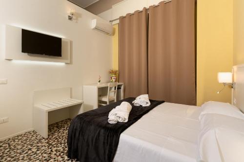 a hotel room with a bed with towels on it at Regina Margherita - Bed and Breakfast & Rooftop Lounge Bar in Siracusa