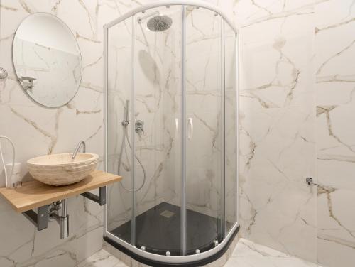a shower with a glass door next to a sink at Regina Margherita - Bed and Breakfast & Rooftop Lounge Bar in Siracusa