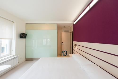a room with a hallway with purple walls at Hotel Boreal Viento Norte in Burgos