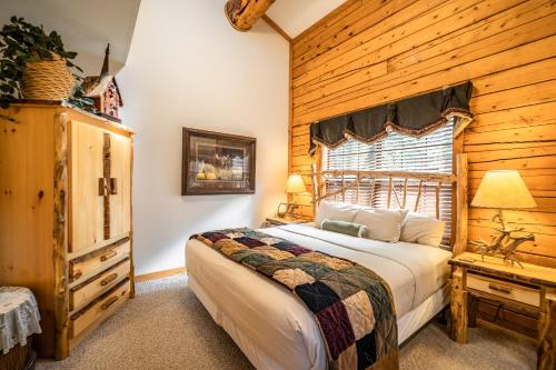 a bedroom with a bed and a wooden wall at Cabins at Grand Mountain in Branson