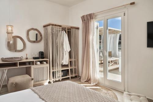 a bedroom with a bed and a sliding glass door at Volcano Luxury Suites Milos - Adults Only in Paliochori