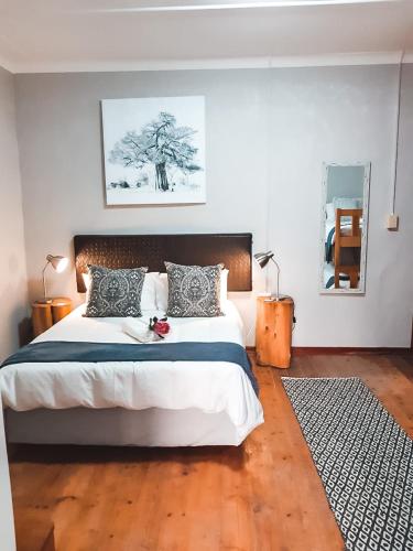 a bedroom with a large bed with a wooden floor at Wiida Gasteplaas in Hopetown