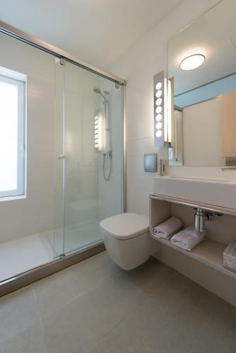 a bathroom with a shower and a toilet and a sink at Hotel Boreal Viento Norte in Burgos