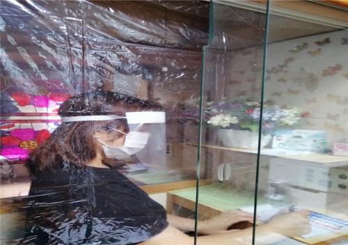 Eine Frau, die in einem Schaufenster eines Ladens sitzt. in der Unterkunft Guest house Hamayu - Vacation STAY 11558v in Katase