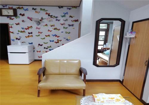 a chair in a room with a mirror and butterflies on the wall at Guest house Hamayu - Vacation STAY 11558v in Katase