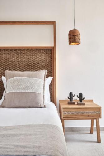 a bedroom with a bed and a table with a night stand at Volcano Luxury Suites Milos - Adults Only in Paliochori