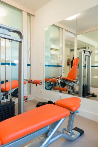 a gym with orange chairs and mirrors at Hotel Boreal Viento Norte in Burgos