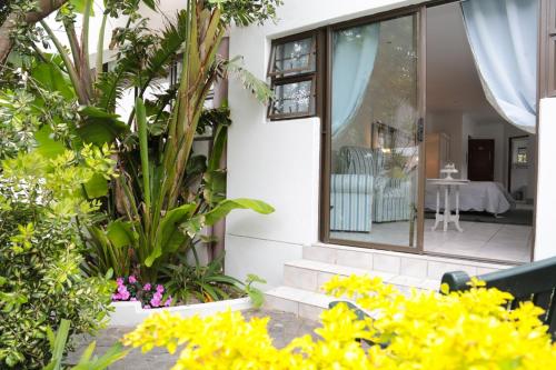 a house with plants and flowers in front of a window at Misty Waves Boutique Hotel in Hermanus