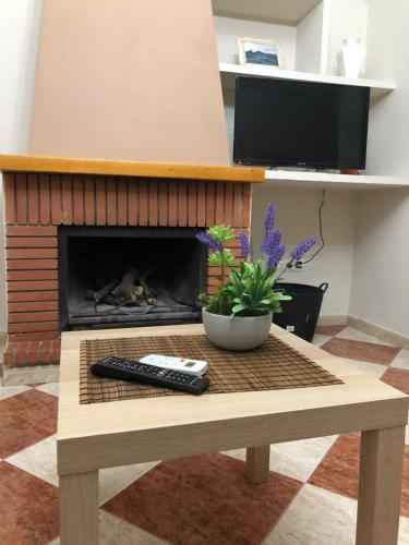 a coffee table with a remote control and a fireplace at Casas PARAJE NATURAL in Zahara de la Sierra