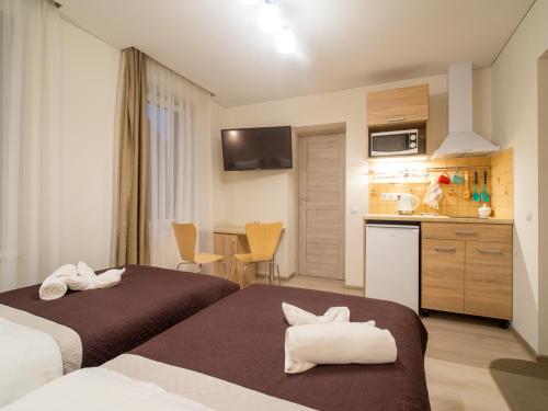 パランガにあるŠarkutėのベッド2台とキッチンが備わるホテルルームです。