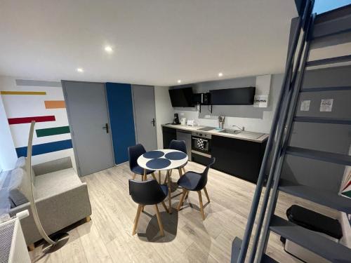 a small kitchen with a table and chairs in a room at Logements équipés à Onnaing avec espace Balneo en OPTION proche Toyota, autoroute et Valenciennes in Onnaing