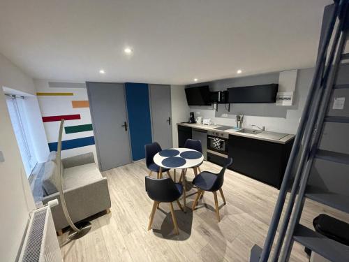 a small kitchen with a table and chairs in a room at Logements équipés à Onnaing avec espace Balneo en OPTION proche Toyota, autoroute et Valenciennes in Onnaing