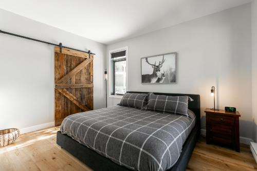 a bedroom with a bed and a window and a door at Le Chalumeau by Chez Tremblant in Mont-Tremblant