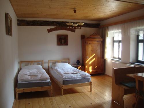 1 dormitorio con 2 camas y techo de madera en Petrovický mlýn, en Kasanice