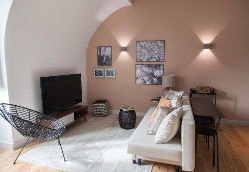 ein Wohnzimmer mit einem Sofa und einem Flachbild-TV in der Unterkunft FLH Intendente Charming Flat in Lissabon