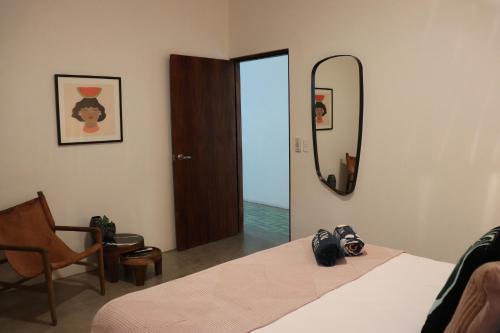 a bedroom with a bed and a mirror and a chair at Residencia Tropical Don Bonito in Sayulita