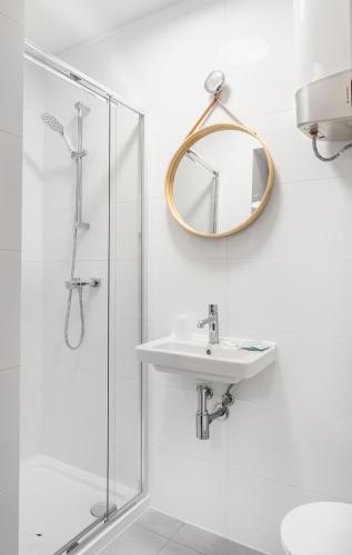a white bathroom with a sink and a mirror at Apartamenty, Boutique Rooms Villa 82, Monitorowany PARKING in Gorzów Wielkopolski