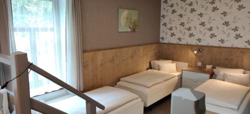 a living room with white furniture and a window at Penzion Bílá voda in Harrachov