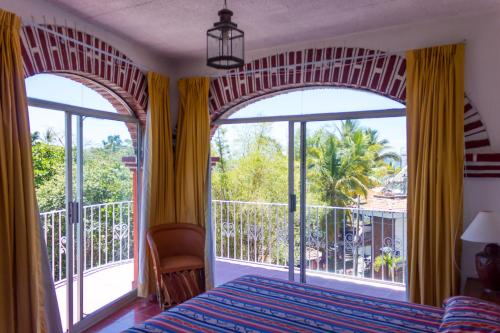 - une chambre avec un lit et une grande fenêtre dans l'établissement Hotel Encino Malecón Centro Puerto Vallarta, à Puerto Vallarta
