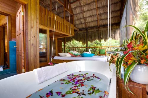 a bath tub with flowers on it in a room at Sweet Songs Jungle Lodge in San Ignacio