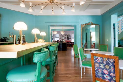 a restaurant with blue walls and green chairs at Bradford House, a Member of Design Hotels in Oklahoma City