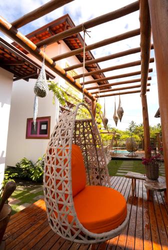 an orange chair sitting on a wooden deck at Vila Lua de Taipu - Taipu de Fora in Barra Grande