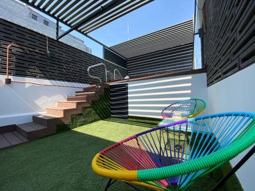 a colorful chair and staircase in a house at Cadillac Hotel Boutique in Mexico City