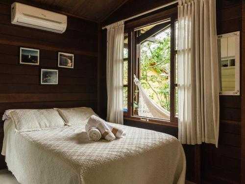 a bedroom with a bed with a towel on it at Kitnet e Suite Morada Aguiar - Chalé in Abraão