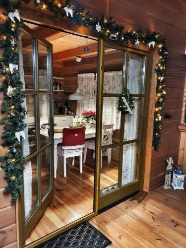a dining room with christmas garland and a table at Dřevěný prázdninový domek SUNRISE in Stará Huť