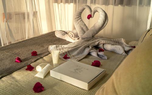 a bed with two swans and a book and roses at Vila Lua de Taipu - Taipu de Fora in Barra Grande