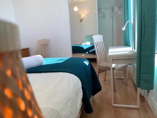 a bedroom with a bed and a desk and a mirror at Chambres EL MEDITERRANEO Rooms in Montréal
