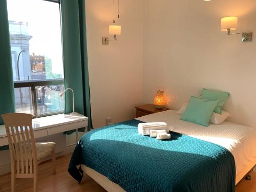 a bedroom with a bed with a desk and a window at Chambres EL MEDITERRANEO Rooms in Montréal