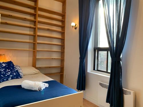 a bedroom with a bunk bed with blue curtains and a window at Chambres EL MEDITERRANEO Rooms in Montréal