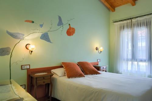 um quarto com uma cama e um mural de árvore na parede em Casa Rural Monfragüe em Villarreal de San Carlos