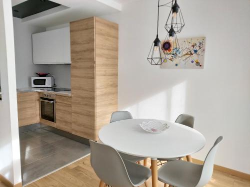 een keuken en eetkamer met een witte tafel en stoelen bij AppartHotel ST MICHEL in Brest