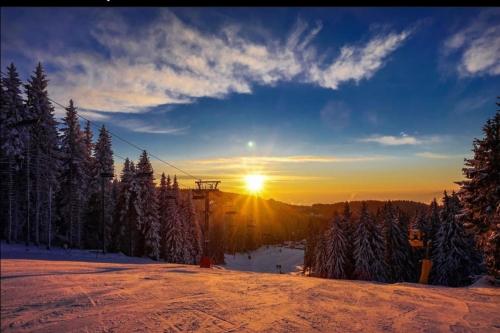 a sunset on a ski slope with a ski lift at Megi apartman - Konaci Maglic in Kopaonik