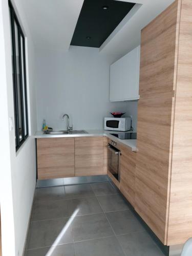 una cocina con armarios de madera y fregadero en AppartHotel ST MICHEL en Brest