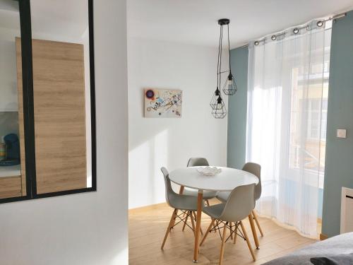 une petite salle à manger avec une table et des chaises blanches dans l'établissement AppartHotel ST MICHEL, à Brest