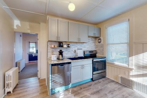 a kitchen with white cabinets and blue appliances at Albert Meadow Hideaway in Bar Harbor