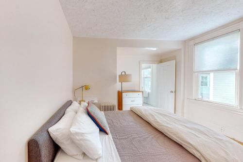 um quarto com uma cama com almofadas e uma janela em Albert Meadow Hideaway em Bar Harbor